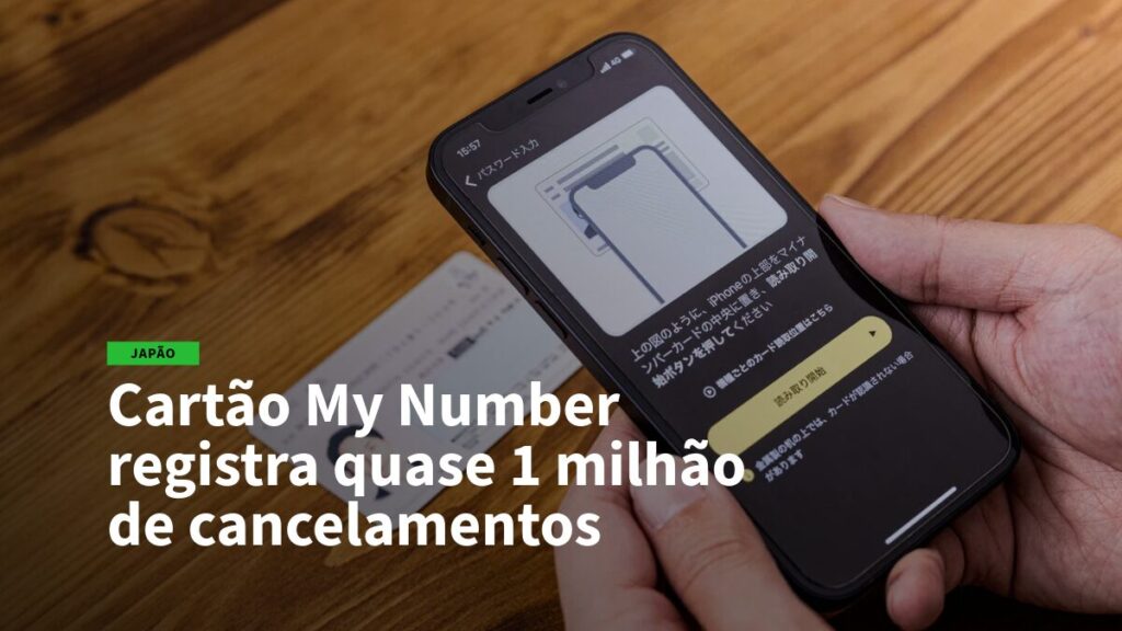 Mão segurando um iPhone com tela de instruções, sobre o Cartão My Number e quase 1 milhão de cancelamentos na manchete em PT-BR.