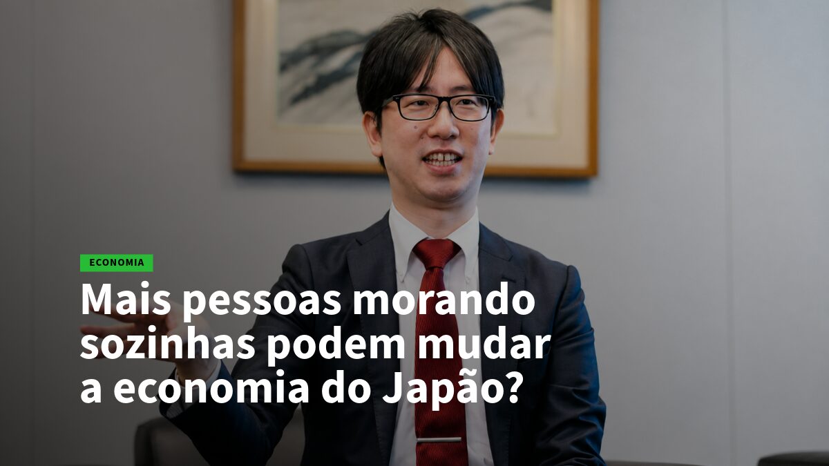 14 - Sozinha - Empregos no Japão Homem de terno com gravata vermelha fala em entrevista; manchete questiona o impacto de morar sozinho na economia do Japão.