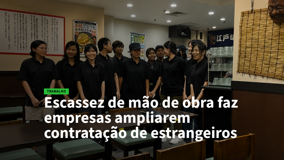 26 - estrangeiros - Empregos no Japão Group of restaurant staff in black uniforms standing together inside a casual dining area, with a Portuguese headline about labor shortages and hiring foreigners overlaid on the image.