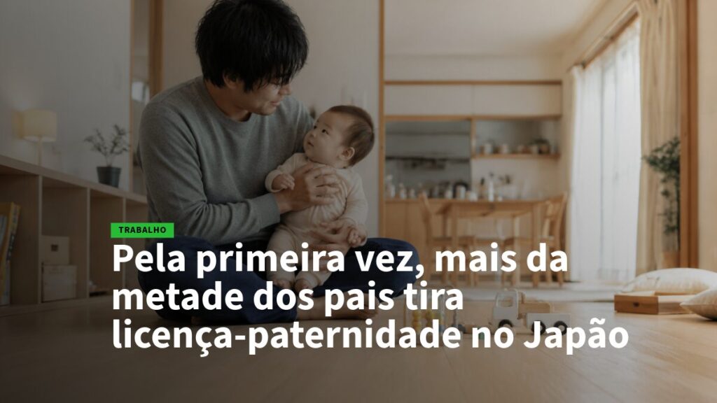 Pai segura bebê no colo enquanto está sentado no chão da sala iluminada, expressão afetuosa. (cena familiar)