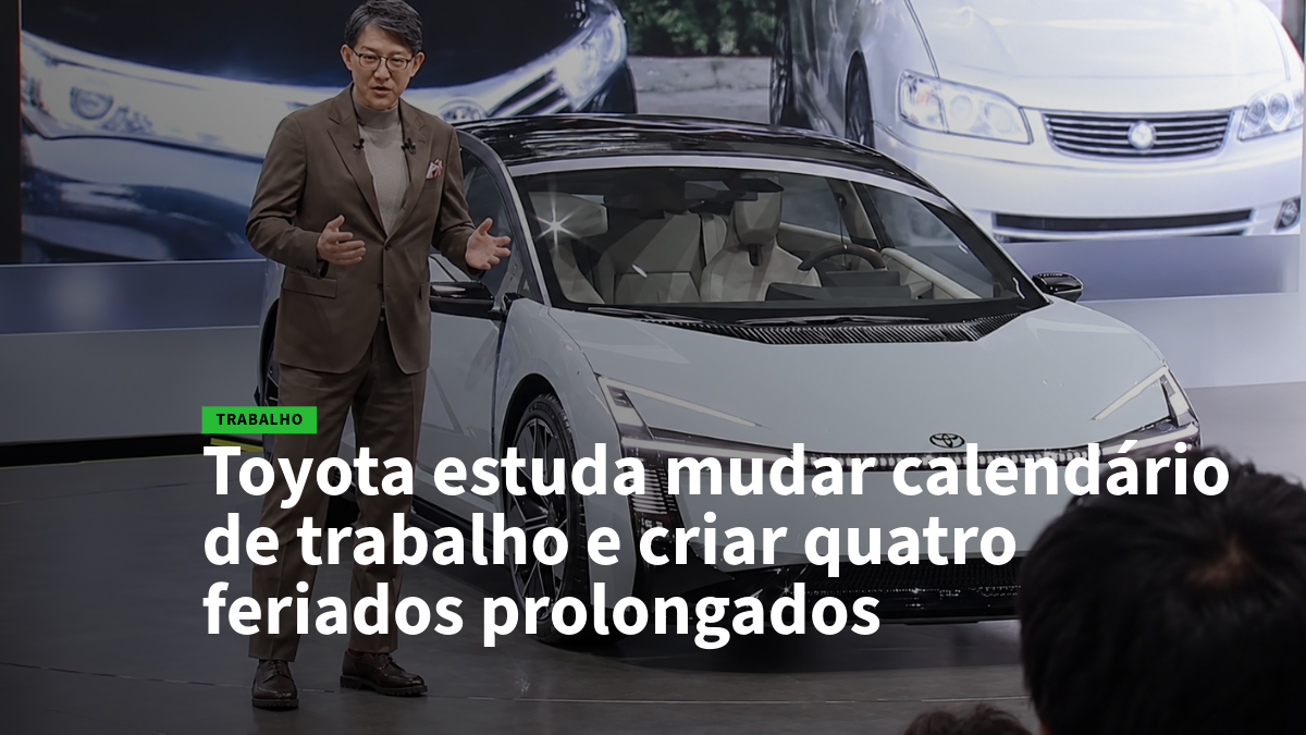 Presenter in a brown suit stands beside a white Toyota on a stage, with a bold article headline about Toyota studying changes to the work calendar and four extended holidays (work topic).