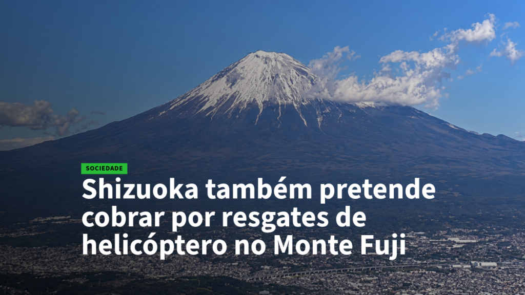 Mount Fuji skyline with a Portuguese headline about Shizuoka charging for helicopter rescues on Mount Fuji, SOCIEDADE tag.